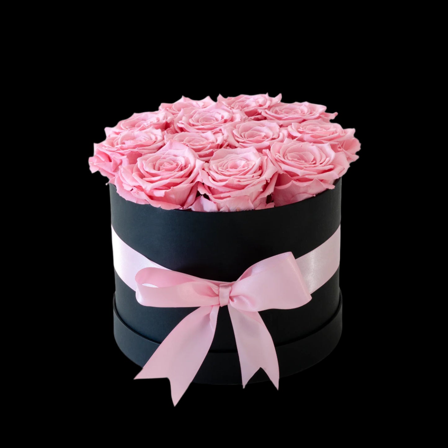Black box with pink roses and a pink ribbon on a white background