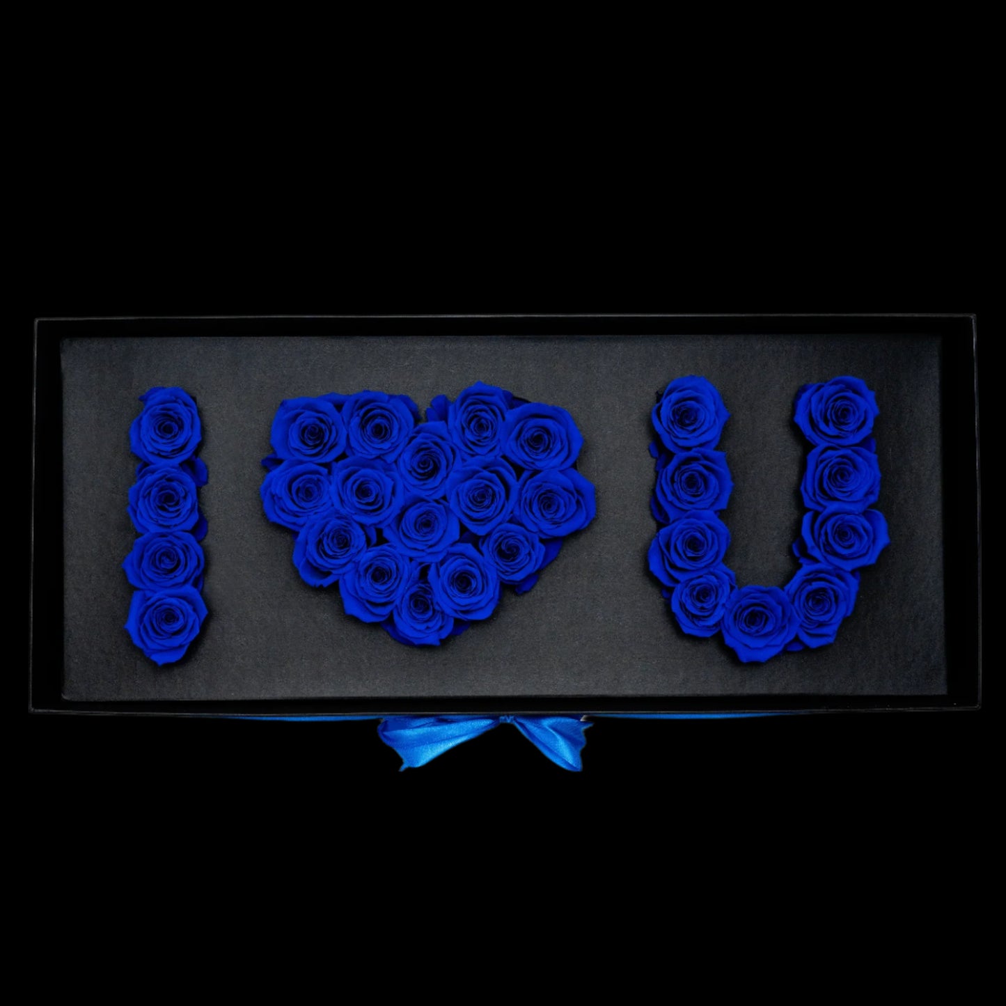 Decorative arrangement of blue roses spelling 'I ❤️ U' on a black background