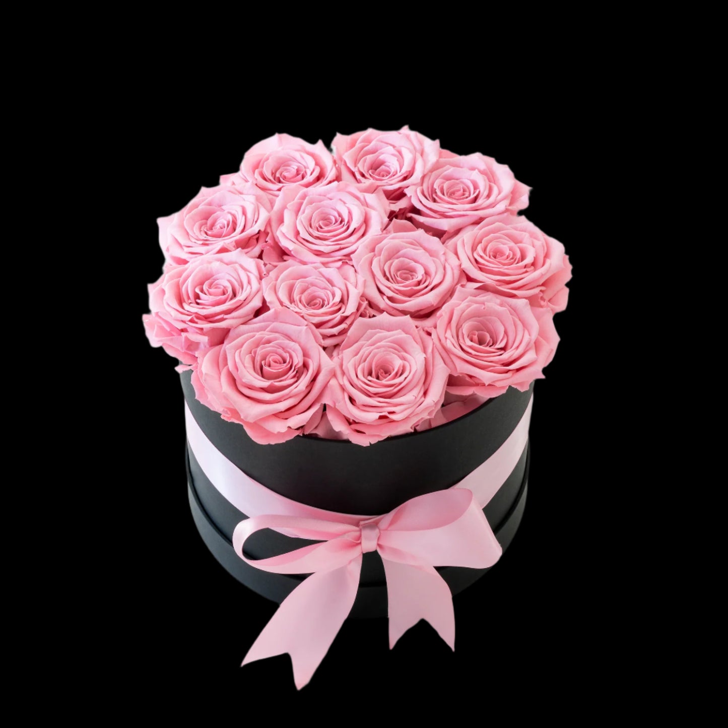 Black box with pink roses and a pink ribbon on a white background