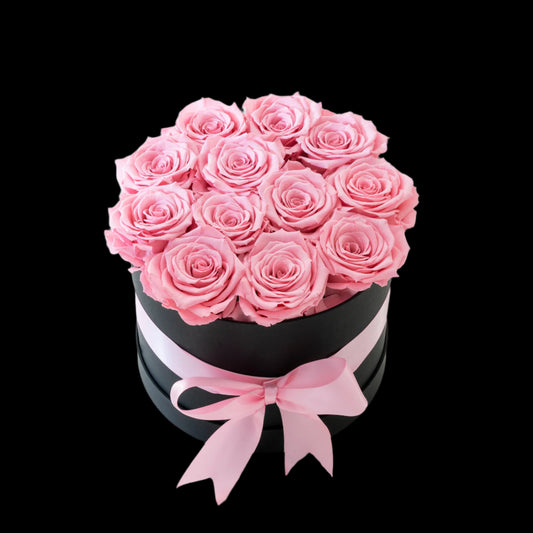 Black box with pink roses and a pink ribbon on a white background