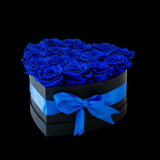 Heart-shaped box filled with blue roses on a white background