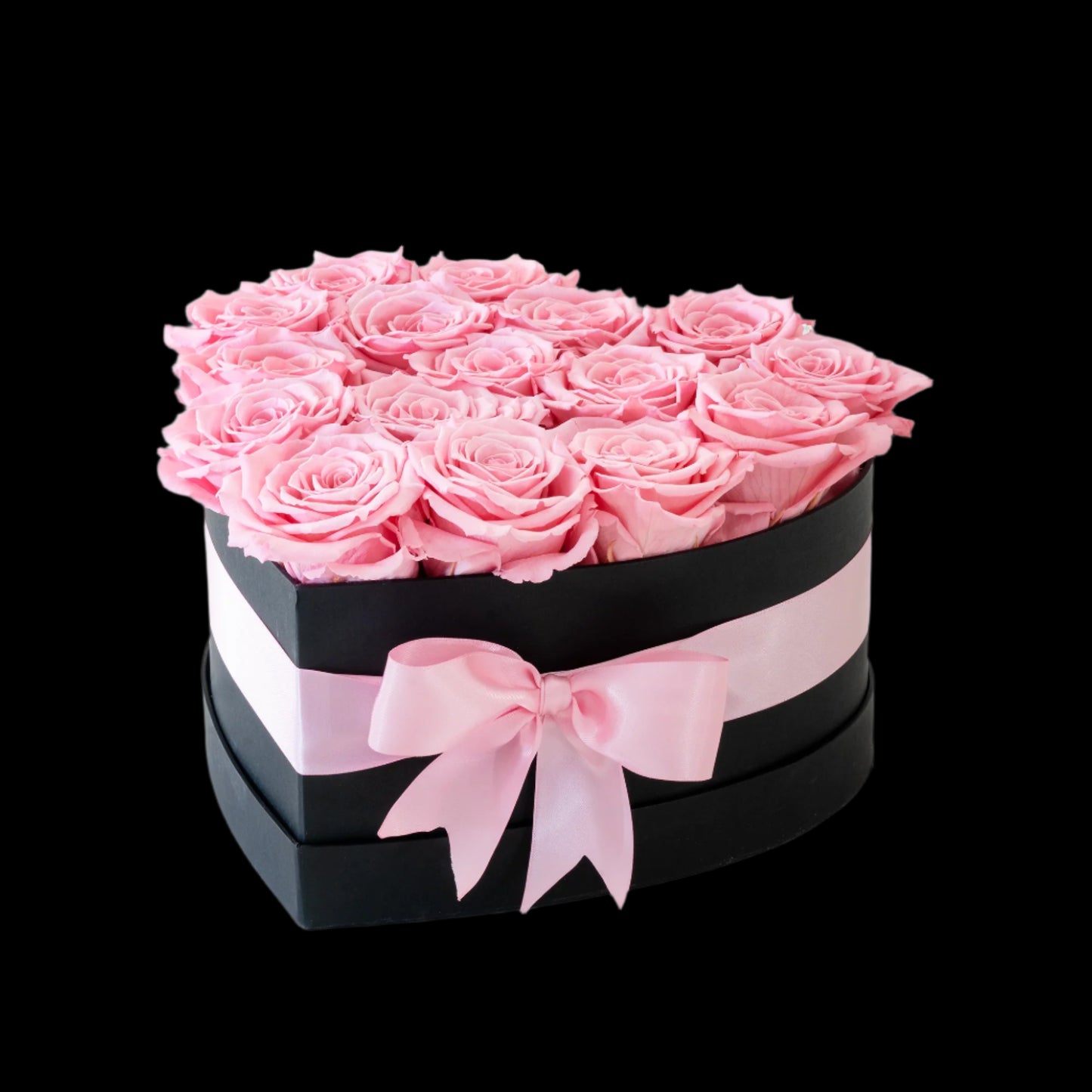 Heart-shaped box of pink roses with a pink ribbon on a white background